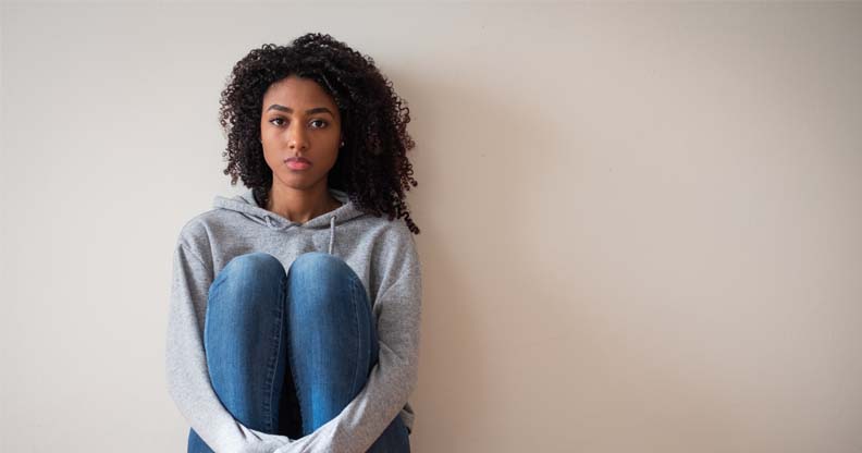 Femme assise contre un mur